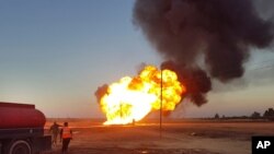 In this photo released by the Syrian official news agency SANA, flames rise from a gas pipeline that hit by an explosion, between the northeastern Damascus suburbs of Adra and Dumair, in Syria, Aug. 24, 2020. 