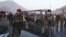 Afghan soldiers stand around a damaged bus at the site of a suicide attack by the Taliban in Kabul, Dec. 13, 2014. 