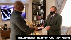 Ntoma ya Amerika na Kinshasas, Michael Hammer "Nzita" (D) apesi mokanda ya président Trump na président Félix Tshisekedi na Kinshasa, RDC, 28 juin 2020. (Twitter/Michael Hammer)