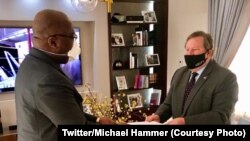 Ntoma ya Amerika na Kinshasas, Michael Hammer "Nzita" (D) apesi mokanda ya président Trump na président Félix Tshisekedi na Kinshasa, RDC, 28 juin 2020. (Twitter/Michael Hammer)