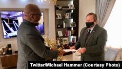 Ntoma ya Amerika na Kinshasas, Michael Hammer "Nzita" (D) apesi mokanda ya président Trump na président Félix Tshisekedi na Kinshasa, RDC, 28 juin 2020. (Twitter/Michael Hammer)