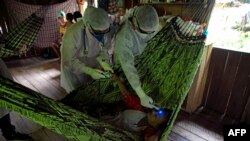 Petugas kesehatan pemerintah mengunjungi masyarakat di bantaran sungai di Melgaco untuk melakukan tes virus corona di kawasan Marajoara, di hulu Sungai Amazon, Brazil, 23 Mei 2020. (Foto: AFP)