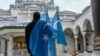 A protester from the Uyghur community living in Turkey stands with flags in the Beyazit mosque during a protest against the visit of China's Foreign Minister to Turkey, in Istanbul on March 25, 2021. 