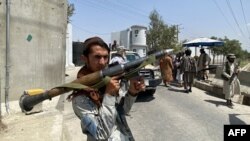 Un combatiente talibán sostiene un lanzagranadas mientras hace guardia con otros en una puerta de entrada frente al Ministerio del Interior en Kabul, Afganistán, el 17 de agosto de 2021.