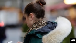 A woman in New York wears a Canada Goose coat with the hood trimmed in coyote fur, Feb. 14, 2019. The fur-trimmed parkas so common on city sidewalks have become a boon to backwoods trappers.
