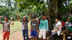 Villagers flash a "peace" sign as government troops arrive to secure their community on the outskirts of Marawi city, May 30, 2017, in the southern Philippines. 