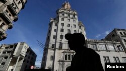 FILE - A man walks in front of the headquarters of Cuba's state-run telecommunications provider ETECSA in Havana, Oct. 24, 2014. 