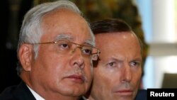 Malaysia's Prime Minister Najib Razak (L) and Australia's Prime Minister Tony Abbott participate in a briefing on the search for Malaysia Airlines flight MH370 at RAAF Base Pearce near Perth, April 3, 2014.