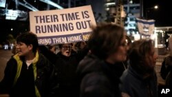 FILE - Protesters try to block a street adjacent to Hostages Square holding signs for the release of the hostages taken by Hamas militants into the Gaza Strip in Tel Aviv, Israel, January 13, 2024.