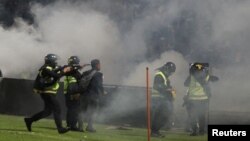 Polisi anti huru hara menembakkan gas air mata saat kerusuhan usai pertandingan sepak bola antara Arema vs Persebaya di Stadion Kanjuruhan, Malang, Jawa Timur, 2 Oktober 2022. (Foto: Antara via Reuters)