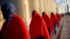 FILE - Migrants, intercepted off the coast in the Mediterranean Sea, walk after disembarking a rescue boat at dawn at the port of Malaga, southern Spain, Dec. 9, 2018. 