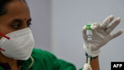 ARCHIVO - Un trabajador de salud se prepara para administrar una dosis de la vacuna Covishield de AstraZeneca-Oxford contra el COVID-19 en un centro de vacunación en Mumbai. Abril 1 de 2021.