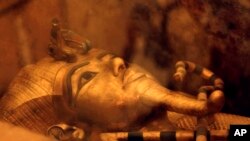 FILE - One of Egypt's famed King Tutankhamun's golden sarcophagus is displayed at his tomb in a glass case at the Valley of the Kings in Luxor, Egypt, April 1, 2016.