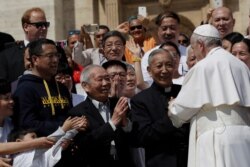 FILE - Pope Francis stops by a group of faithful from Shanghai during his weekly general audience in St. Peter's square, at the Vatican, May 22, 2019.