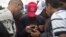 FILE - Migrants heading for Austria consult a map on a cell phone, in Budapest, Hungary, Sept. 5, 2015.
