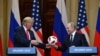 FINLAND -- Russia's President Vladimir Putin (R) offers a ball of the 2018 football World Cup to US President Donald Trump during a joint press conference after a meeting at the Presidential Palace in Helsinki, on July 16, 2018.