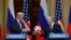 FINLAND -- Russia's President Vladimir Putin (R) offers a ball of the 2018 football World Cup to US President Donald Trump during a joint press conference after a meeting at the Presidential Palace in Helsinki, on July 16, 2018.