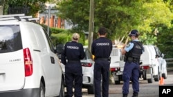 FILE - Police stand near houses vandalized with anti-Israel slogans in the Sydney suburb of Woollahra, Australia, Wednesday, Dec. 11, 2024. 