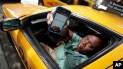 FILE - Taxi driver Roland Sainristil displays the driver's ZabKab app on his smartphone, in New York, Aug. 8, 2012. The app lets a passenger send out a hailing signal to all cabs within a four- or five-block area. Now, however, cabs themselves are in for makeovers that will make for a more pleasant passenger experience.