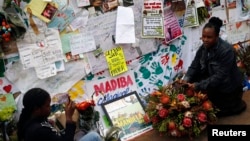 Well-wishers take photographs outside the hospital where ailing former President Nelson Mandela is being treated in Pretoria, South Africa, July 10, 2013. 