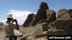 In this photo, tourist Chris Farthing of Suffolks County, England, takes a picture while visiting Chaco Culture National Historical Park in northwestern, New Mexico.