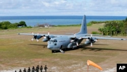 Binh sĩ Philippines chào đón Bộ trưởng Quốc phòng Delfin Lorenzana, Tư lệnh Không quân Eduardo Ano và các quan chức Philippines khác đáp vận tải cơ C-130 xuống đường trải đá trên đảo Thị Tứ (ảnh tư liệu ngày 21/4/2017).