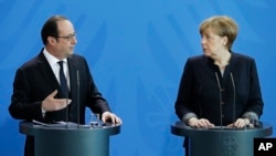 German Chancellor Angela Merkel, right, and the President of France, Francois Hollande, left, address the media during a joint statement as part of a meeting at the chancellery in Berlin, Germany, Jan. 27, 2017.