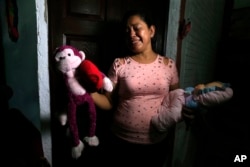Rosa Ramirez sobs as she shows journalists toys that belonged to her nearly 2-year-old granddaughter Valeria in her home in San Martin, El Salvador, Tuesday, June 25, 2019. (AP Photo/Antonio Valladares)