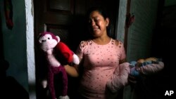 Rosa Ramirez menangis saat menunjukkan mainan milik cucu perempuannya yang berusia 2 tahun, Valeria, di rumah di San Martin, El Salvador, 25 Juni 2019. Valeria dan ayahnya, Oscar Alberto Martinez, tewas terseret arus sungai saat berusaha mencapai perbatasan AS. (Foto: AP)