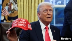 El presidente Donald Trump sostiene una gorra en la que se lee "Trump tenía razón en todo", después de firmar una orden ejecutiva en la Casa Blanca, el 25 de febrero de 2025.