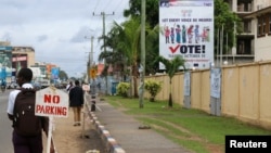 FILE - People walk past the headquarters of Liberia's National Elections Commission (NEC) in the Sinkor neighborhood of Monrovia, Liberia Nov. 6, 2017. 