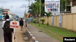 FILE - People walk past the headquarters of Liberia's National Elections Commission (NEC) in the Sinkor neighborhood of Monrovia, Liberia Nov. 6, 2017. 