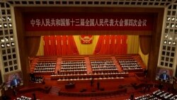 With screens showing Chinese President Xi Jinping, delegates attend the opening session of China's National People's Congress (NPC) at the Great Hall of the People in Beijing on Friday, March 5, 2021. 