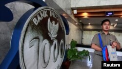 Seorang pengunjung berjalan melintasi model koin Rupiah yang dipamerkan di Gedung Bank Indonesia, di Jakarta, Indonesia 19 Januari 2017. REUTERS/Fatima El-Kareem