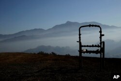 A charred lawn chair overlooks a valley filled with smoke from the Kincade Fire near Healdsburg, Calif., Nov. 1, 2019.