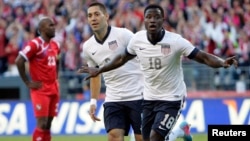 Eddie Johnson del equipo estadounidense celebra el gol con su compañero Clint Dempsey calificando para el mundial 2014.