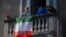 Une femme place un drapeau italien qui proclame que "tout ira bien", du balcon de son appartement où elle est confinée à Milan, Italie, le 16 mars 2020. REUTERS / Daniele Mascolo
