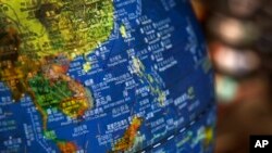 FILE - In this July 13, 2018, photo, a globe shows the islands on the South China Sea with nine-dash line claims under Chinese territory on display at a bookstore in Beijing.