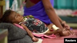 An infant lies in bed in a malnutrition intensive care unit in Dharbhanga, India, April 16, 2015. Researchers thought stunting was mostly caused by malnutrition, but a study indicates a parasite may be a factor.