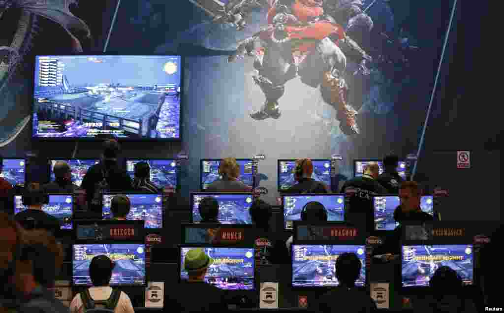 Visitors play the &quot;Final Fantasy XIV: A Realm Reborn&quot; video game at an exhibition stand during the Gamescom 2014 fair in Cologne, Germany. The Gamescom convention, Europe&#39;s largest video games trade fair, runs from Aug. 13 to 17.