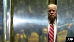 FILE - Donald Trump boards the elevator at Trump Tower in New York City, Jan. 16, 2017.