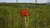 A warning sign stands in a field contaminated with dioxin near Danang airport, during a ceremony marking the start of a project to clean up dioxin left over from the Vietnam War, at a former U.S. military base in Danang, Vietnam, August 9, 2012.