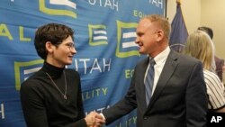 Nathan Dalley, left, shakes hands with Republican Utah Rep. Craig Hall following a news conference about the discredited practice of conversion therapy for LGBTQ children, now banned in Utah Wednesday, Jan. 22, 2020, in Salt Lake City.