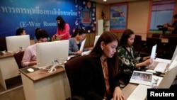 FILE - Government staff work as they monitor social media in a social media war room in Bangkok, March 8, 2019. 