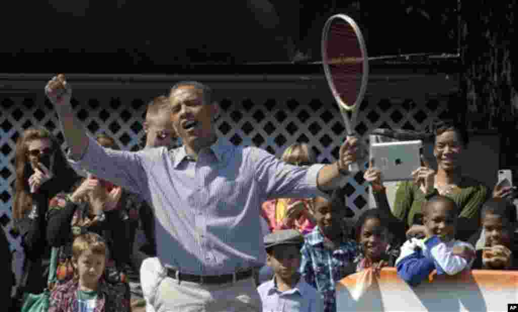 President Barack Obama reacts while playing tennis during the annual Easter Egg Roll on the South Lawn of the White House in Washington, Monday, April 1, 2013. (AP Photo/Susan Walsh)