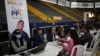 FILE - Colombian Migration employees work during a day of Temporary Protection Permit deliveries organized by Colombian Migration at the Sports Palace in Bogota, Colombia, Sept. 1, 2023.