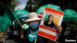 Una manifestante porta una fotografía de una mujer desaparecida en El Salvador durante una marcha por el Día de Acción por la Salud de la Mujer el 28 de mayo de 2021.