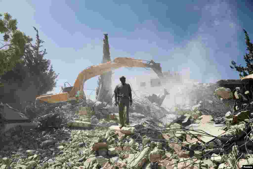 Palestinian Jihad Shawamrah stands on the ruins of his house that he demolished to not face the prospect of Israeli settlers moving in after he lost a land ownership case in Israeli courts, in the East Jerusalem neighbourhood of Beit Hanina, July 19, 2018