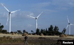 FILE - A man walks near the Adama wind farm project built by Chinese Exim Bank on the outskirt of Adama Town, east of the capital Addis Ababa, Nov. 5, 2015.