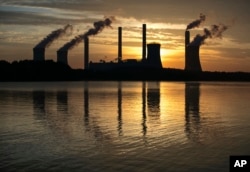 FILE - The coal-fired Plant Scherer, one of the nation's top carbon dioxide emitters, stands in the distance in Juliette, Ga., June 3, 2017. The Trump administration intends to roll back the centerpiece of former President Barack Obama’s efforts to slow the build up of greenhouse gases.